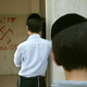 Jewish boys look at anti-Semitic graffiti which was sprayed on the walls of a synagogue March 5, 2006